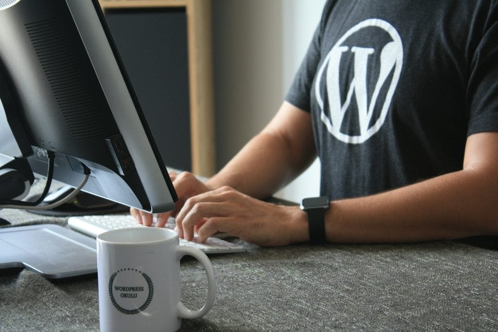 Kiến Trúc Nền Tảng: Nên Dùng Laravel Hay WordPress? 2 person in black and white t-shirt using computer